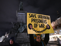 KRAKOW, POLAND - NOVEMBER 28:
A protester wearing a wreath in Ukrainian colors holds a poster reading 'Save Ukrainian Prisoniers of War' on...