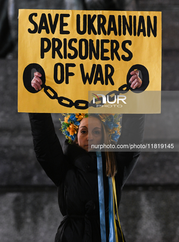 KRAKOW, POLAND - NOVEMBER 28:
A protester wearing a wreath in Ukrainian colors holds a poster reading 'Save Ukrainian Prisoniers of War' on...