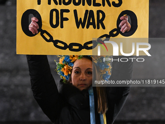 KRAKOW, POLAND - NOVEMBER 28:
A protester wearing a wreath in Ukrainian colors holds a poster reading 'Save Ukrainian Prisoniers of War' on...