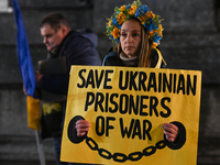 KRAKOW, POLAND - NOVEMBER 28:
A protester wearing a wreath in Ukrainian colors holds a poster reading 'Save Ukrainian Prisoniers of War' on...