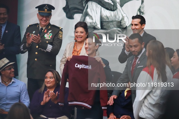 Mexico's President Claudia Sheinbaum Pardo holds a sweatshirt during the National Sports Award 2024 at the National Palace in Mexico City, M...