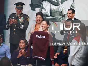 Mexico's President Claudia Sheinbaum Pardo holds a sweatshirt during the National Sports Award 2024 at the National Palace in Mexico City, M...