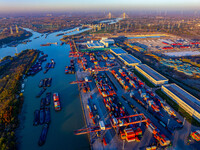 Containers wait to be loaded and unloaded at the terminal of Huaian Port Logistics Group in Huai'an, Jiangsu province, China, on November 29...