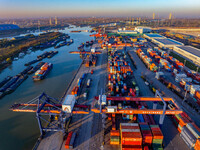 Containers wait to be loaded and unloaded at the terminal of Huaian Port Logistics Group in Huai'an, Jiangsu province, China, on November 29...