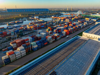 Containers wait to be loaded and unloaded at the terminal of Huaian Port Logistics Group in Huai'an, Jiangsu province, China, on November 29...