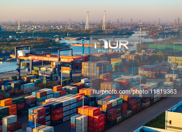 Containers wait to be loaded and unloaded at the terminal of Huaian Port Logistics Group in Huai'an, Jiangsu province, China, on November 29...