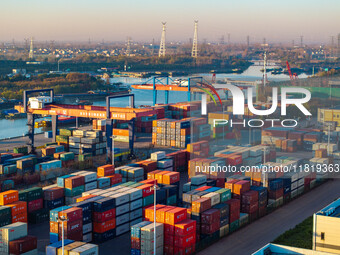 Containers wait to be loaded and unloaded at the terminal of Huaian Port Logistics Group in Huai'an, Jiangsu province, China, on November 29...