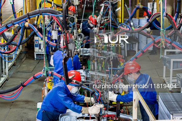 Workers work on the production line at the production workshop of Qingdao Wushun Auto Mold Parts Co., LTD., in West Coast New Area, Qingdao,...