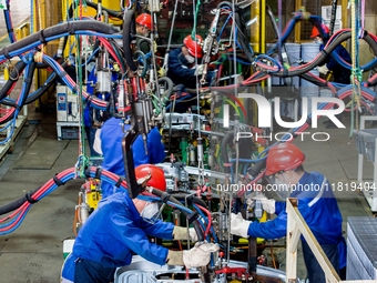 Workers work on the production line at the production workshop of Qingdao Wushun Auto Mold Parts Co., LTD., in West Coast New Area, Qingdao,...