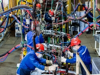 Workers work on the production line at the production workshop of Qingdao Wushun Auto Mold Parts Co., LTD., in West Coast New Area, Qingdao,...