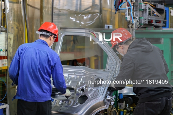 Workers work on the production line at the production workshop of Qingdao Wushun Auto Mold Parts Co., LTD., in West Coast New Area, Qingdao,...