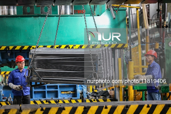 Workers work on the production line at the production workshop of Qingdao Wushun Auto Mold Parts Co., LTD., in West Coast New Area, Qingdao,...