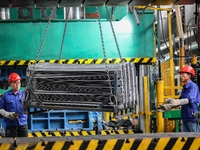 Workers work on the production line at the production workshop of Qingdao Wushun Auto Mold Parts Co., LTD., in West Coast New Area, Qingdao,...