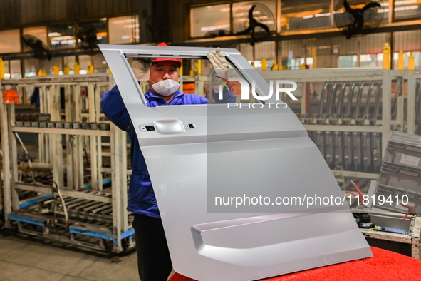 Workers work on the production line at the production workshop of Qingdao Wushun Auto Mold Parts Co., LTD., in West Coast New Area, Qingdao,...