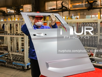 Workers work on the production line at the production workshop of Qingdao Wushun Auto Mold Parts Co., LTD., in West Coast New Area, Qingdao,...