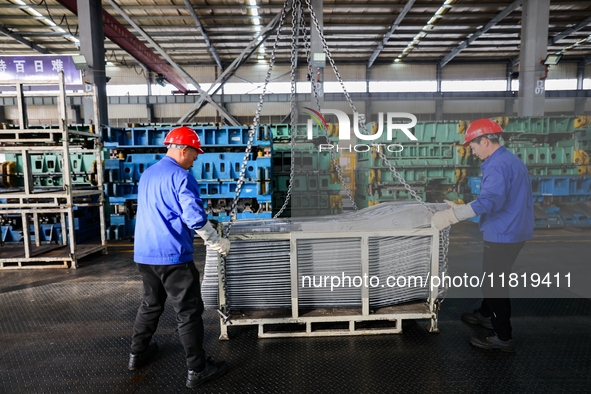 Workers work on the production line at the production workshop of Qingdao Wushun Auto Mold Parts Co., LTD., in West Coast New Area, Qingdao,...