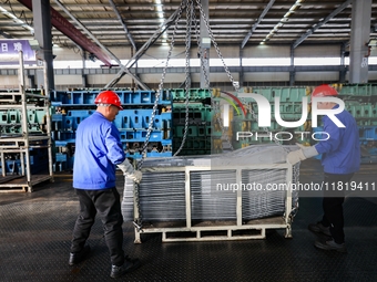 Workers work on the production line at the production workshop of Qingdao Wushun Auto Mold Parts Co., LTD., in West Coast New Area, Qingdao,...