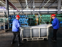 Workers work on the production line at the production workshop of Qingdao Wushun Auto Mold Parts Co., LTD., in West Coast New Area, Qingdao,...