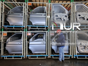 Workers work on the production line at the production workshop of Qingdao Wushun Auto Mold Parts Co., LTD., in West Coast New Area, Qingdao,...