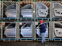 Workers work on the production line at the production workshop of Qingdao Wushun Auto Mold Parts Co., LTD., in West Coast New Area, Qingdao,...