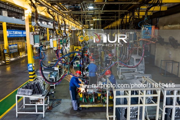 Workers work on the production line at the production workshop of Qingdao Wushun Auto Mold Parts Co., LTD., in West Coast New Area, Qingdao,...