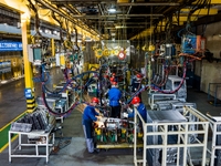 Workers work on the production line at the production workshop of Qingdao Wushun Auto Mold Parts Co., LTD., in West Coast New Area, Qingdao,...