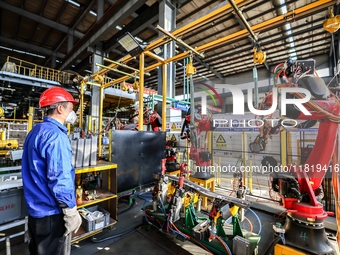 Workers work on the production line at the production workshop of Qingdao Wushun Auto Mold Parts Co., LTD., in West Coast New Area, Qingdao,...