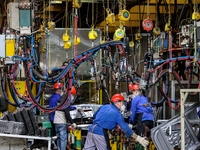 Workers work on the production line at the production workshop of Qingdao Wushun Auto Mold Parts Co., LTD., in West Coast New Area, Qingdao,...