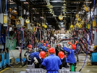 Workers work on the production line at the production workshop of Qingdao Wushun Auto Mold Parts Co., LTD., in West Coast New Area, Qingdao,...