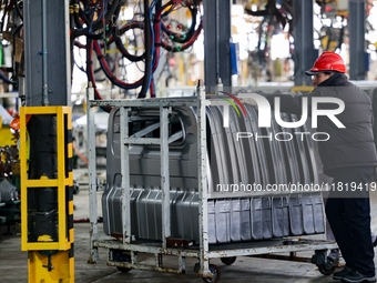 Workers work on the production line at the production workshop of Qingdao Wushun Auto Mold Parts Co., LTD., in West Coast New Area, Qingdao,...