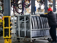 Workers work on the production line at the production workshop of Qingdao Wushun Auto Mold Parts Co., LTD., in West Coast New Area, Qingdao,...