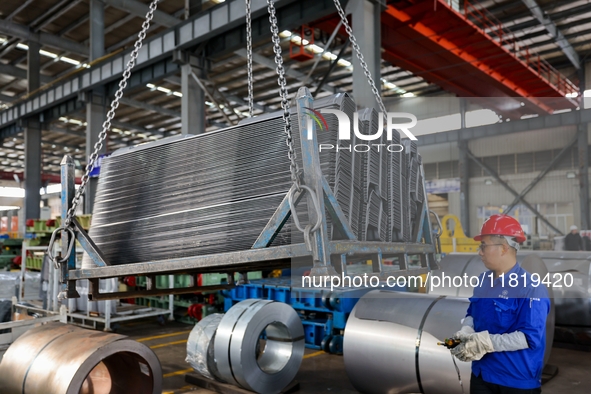 Workers work on the production line at the production workshop of Qingdao Wushun Auto Mold Parts Co., LTD., in West Coast New Area, Qingdao,...