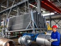 Workers work on the production line at the production workshop of Qingdao Wushun Auto Mold Parts Co., LTD., in West Coast New Area, Qingdao,...