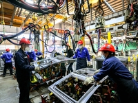 Workers work on the production line at the production workshop of Qingdao Wushun Auto Mold Parts Co., LTD., in West Coast New Area, Qingdao,...