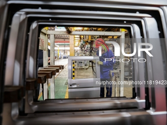 Workers work on the production line at the production workshop of Qingdao Wushun Auto Mold Parts Co., LTD., in West Coast New Area, Qingdao,...