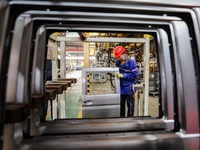 Workers work on the production line at the production workshop of Qingdao Wushun Auto Mold Parts Co., LTD., in West Coast New Area, Qingdao,...