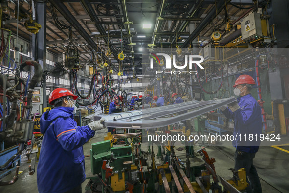 Workers work on the production line at the production workshop of Qingdao Wushun Auto Mold Parts Co., LTD., in West Coast New Area, Qingdao,...