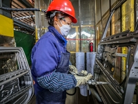 Workers work on the production line at the production workshop of Qingdao Wushun Auto Mold Parts Co., LTD., in West Coast New Area, Qingdao,...