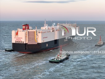 The car carrier ''BYD Changzhou'' departs with the assistance of a tugboat at CIMC Raffles' Shandong Longkou construction base in Yantai, Ch...