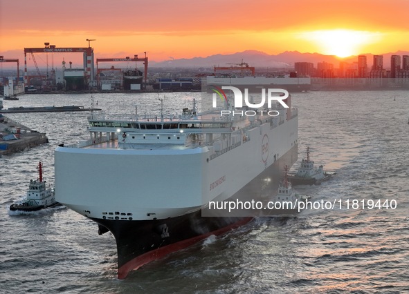 The car carrier ''BYD Changzhou'' departs with the assistance of a tugboat at CIMC Raffles' Shandong Longkou construction base in Yantai, Ch...