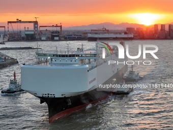 The car carrier ''BYD Changzhou'' departs with the assistance of a tugboat at CIMC Raffles' Shandong Longkou construction base in Yantai, Ch...