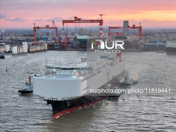 The car carrier ''BYD Changzhou'' departs with the assistance of a tugboat at CIMC Raffles' Shandong Longkou construction base in Yantai, Ch...