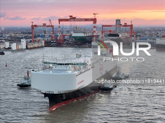 The car carrier ''BYD Changzhou'' departs with the assistance of a tugboat at CIMC Raffles' Shandong Longkou construction base in Yantai, Ch...