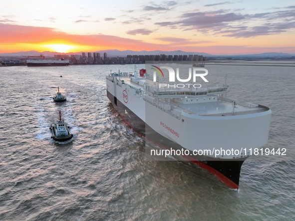 The car carrier ''BYD Changzhou'' departs with the assistance of a tugboat at CIMC Raffles' Shandong Longkou construction base in Yantai, Ch...