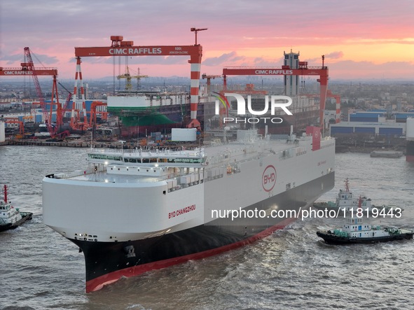 The car carrier ''BYD Changzhou'' departs with the assistance of a tugboat at CIMC Raffles' Shandong Longkou construction base in Yantai, Ch...