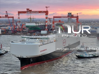 The car carrier ''BYD Changzhou'' departs with the assistance of a tugboat at CIMC Raffles' Shandong Longkou construction base in Yantai, Ch...