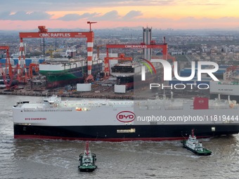 The car carrier ''BYD Changzhou'' departs with the assistance of a tugboat at CIMC Raffles' Shandong Longkou construction base in Yantai, Ch...