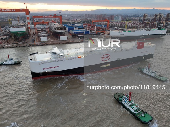 The car carrier ''BYD Changzhou'' departs with the assistance of a tugboat at CIMC Raffles' Shandong Longkou construction base in Yantai, Ch...