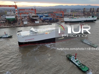 The car carrier ''BYD Changzhou'' departs with the assistance of a tugboat at CIMC Raffles' Shandong Longkou construction base in Yantai, Ch...