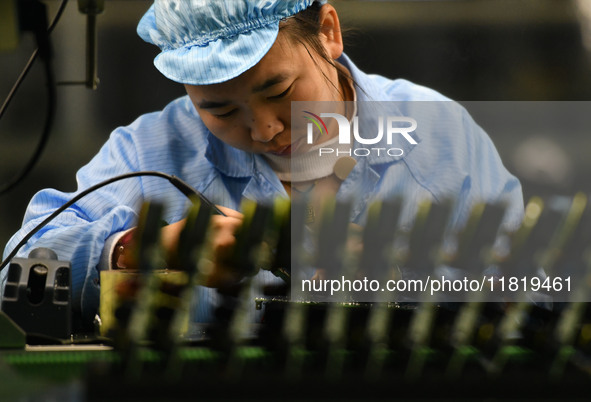 An employee works on a circuit board production line at the workshop of Anhui Shixin Electronic Technology Co LTD in Fuyang, China, on Novem...